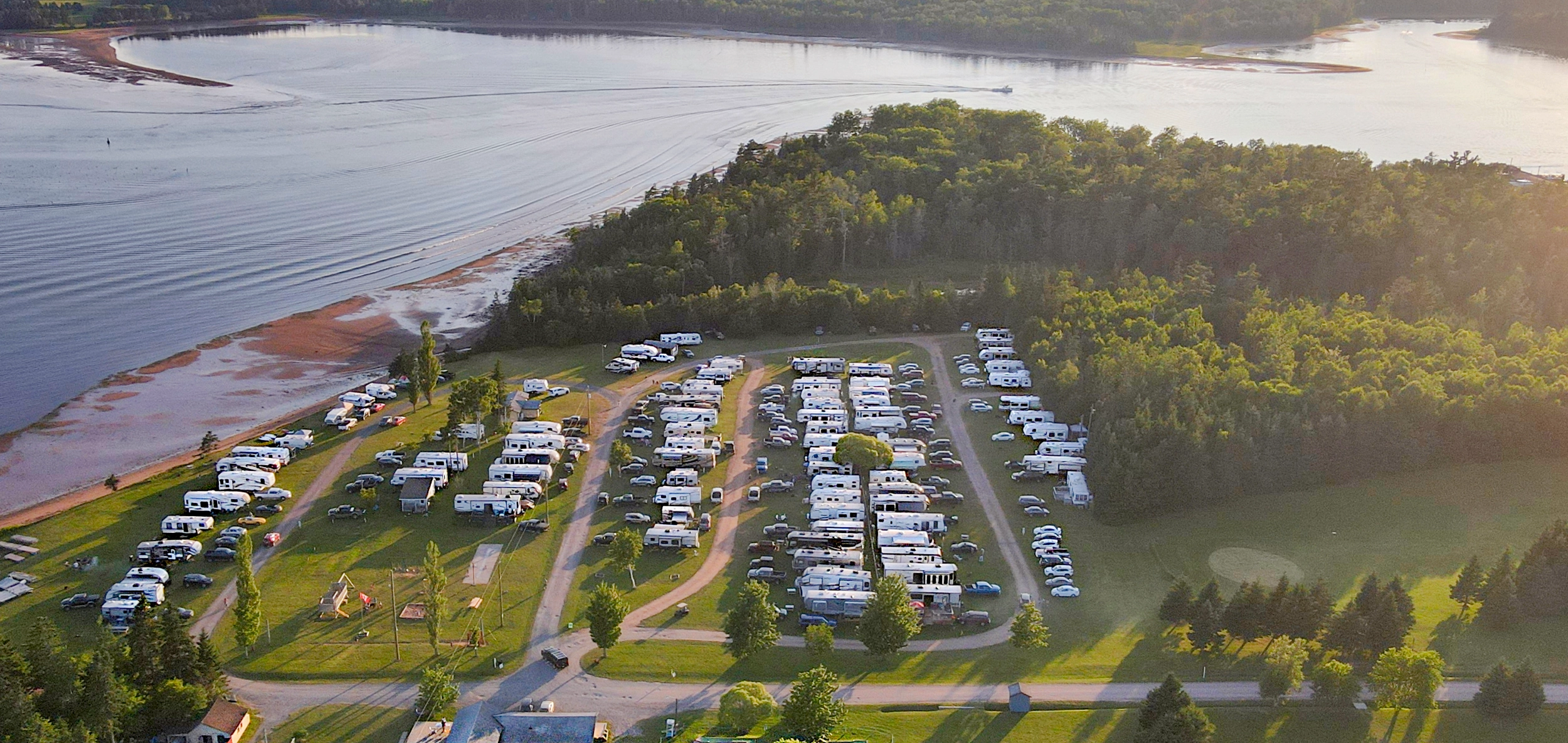 Aerial view of Seal Cove Campground on the shore of Murray Bay at golden hour