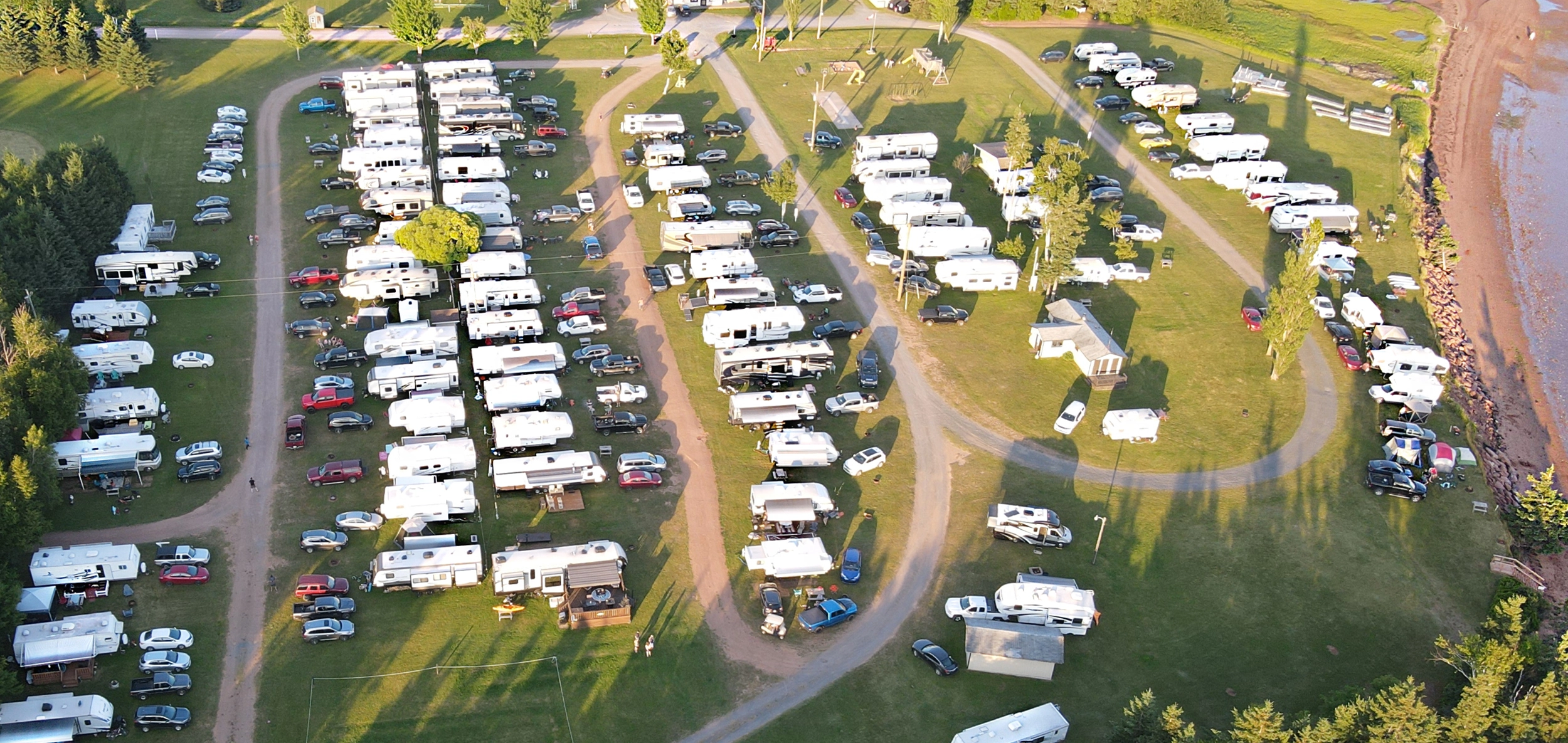 Aerial view of RV and trailer sites at Seal Cove Campground beside the bay