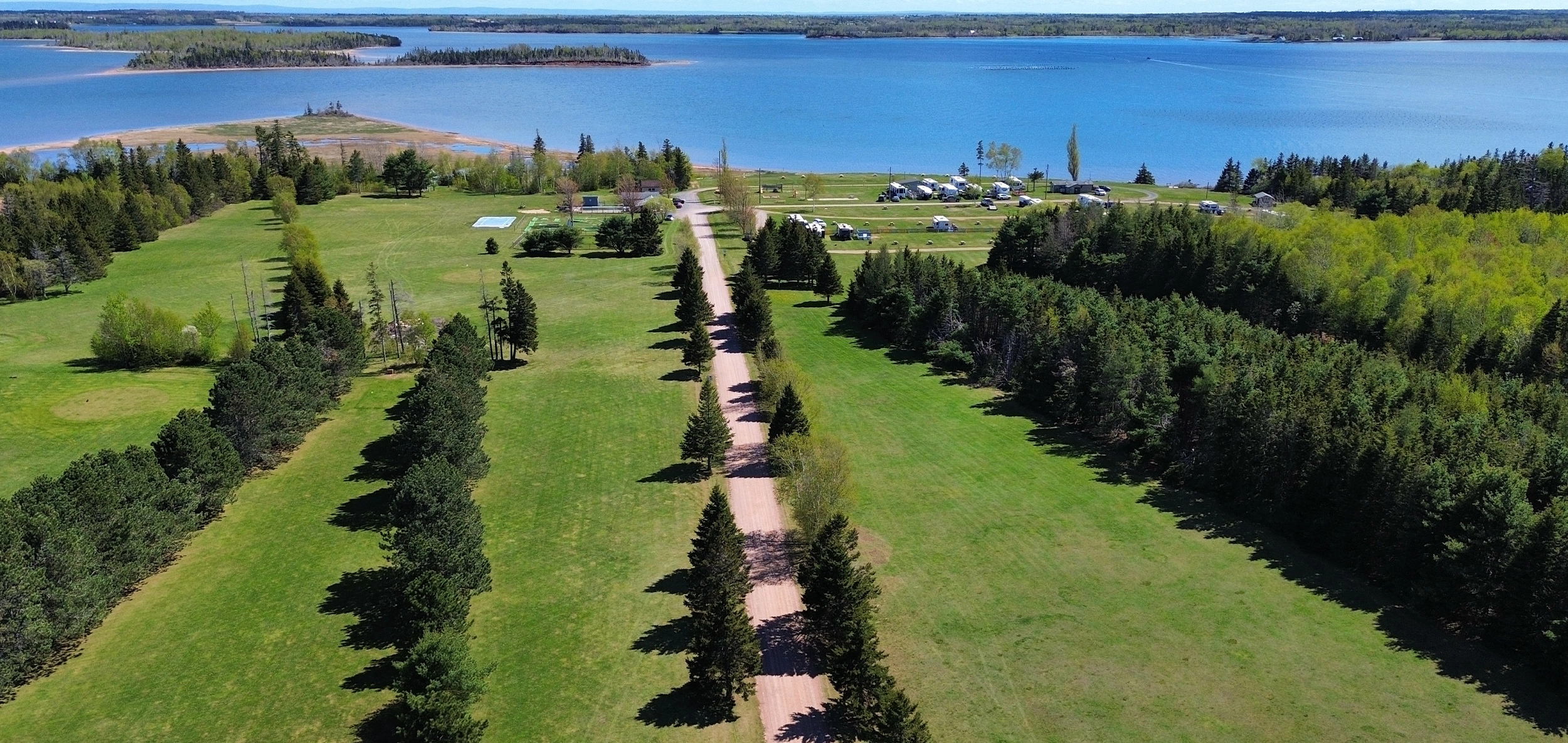 Aerial view of Seal Cove's tree-lined grounds, pool and campsites along the bay